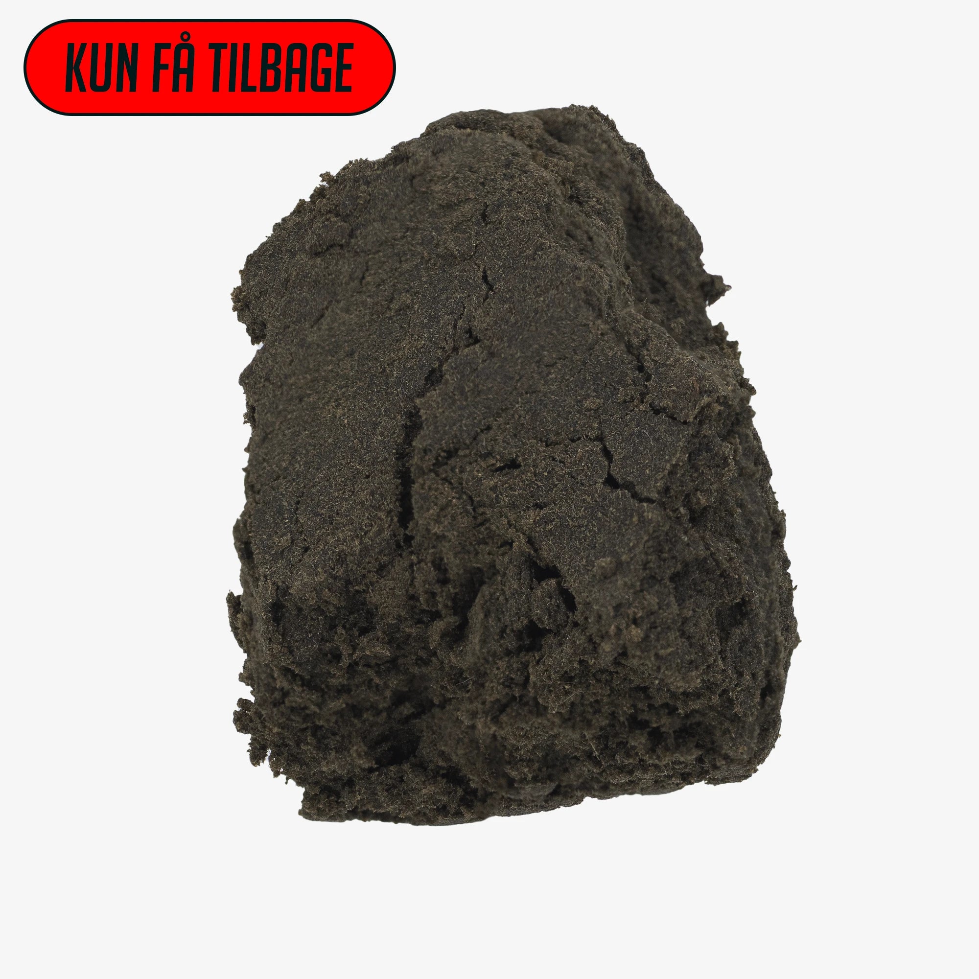 Formet klump af mørkebrun hash med kompakt og ensartet tekstur, fotograferet mod hvid baggrund.